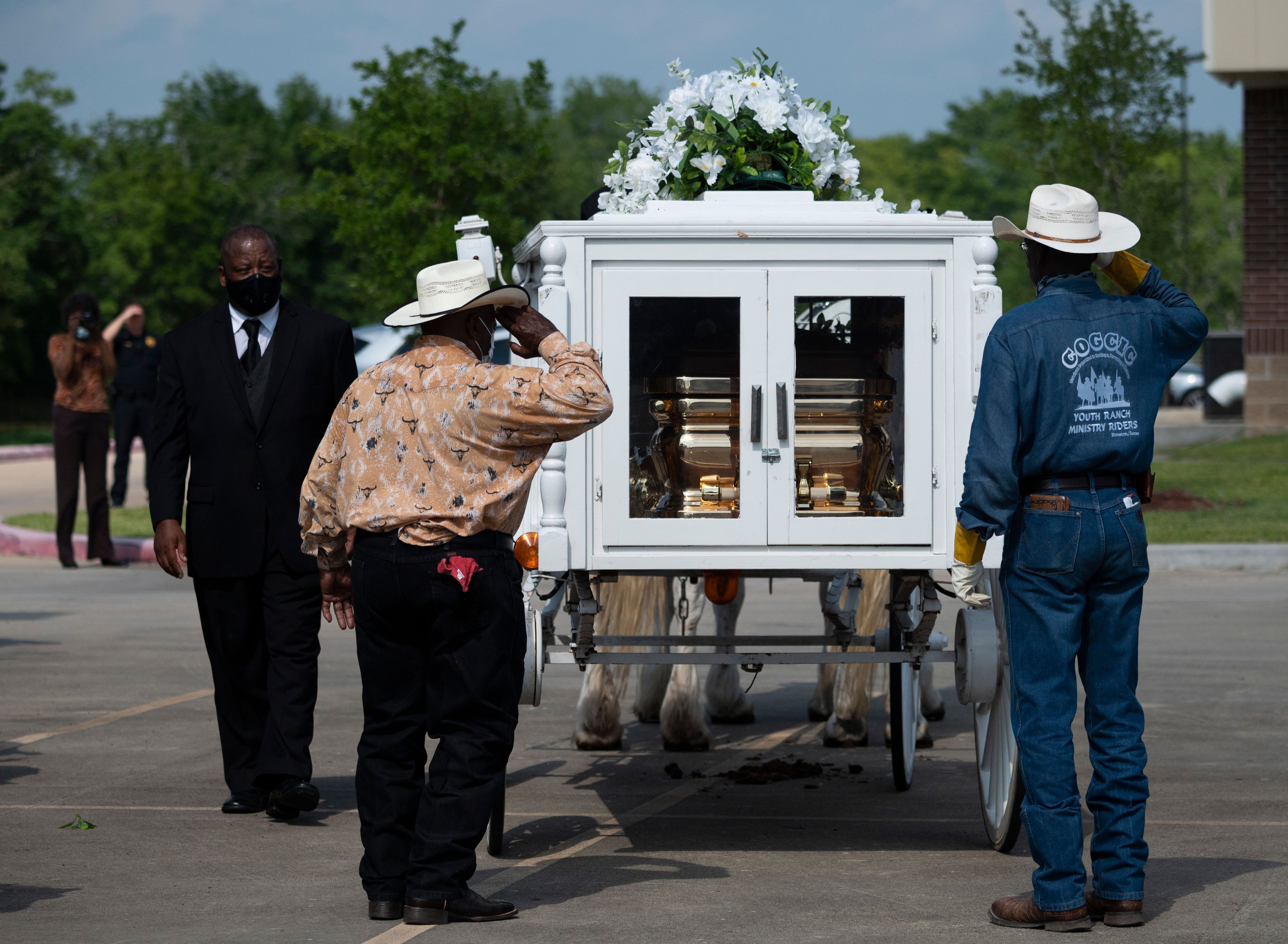 Two cowboys salute the casket of George Floyd after it was loaded onto a white horse-drawn carriage to be taken to his final resting place at the Houston Memorial Gardens, the culmination of a long farewell to the 46-year-old African American whose death in custody ignited global protests against police brutality and racism. 1T61JZ.jpg