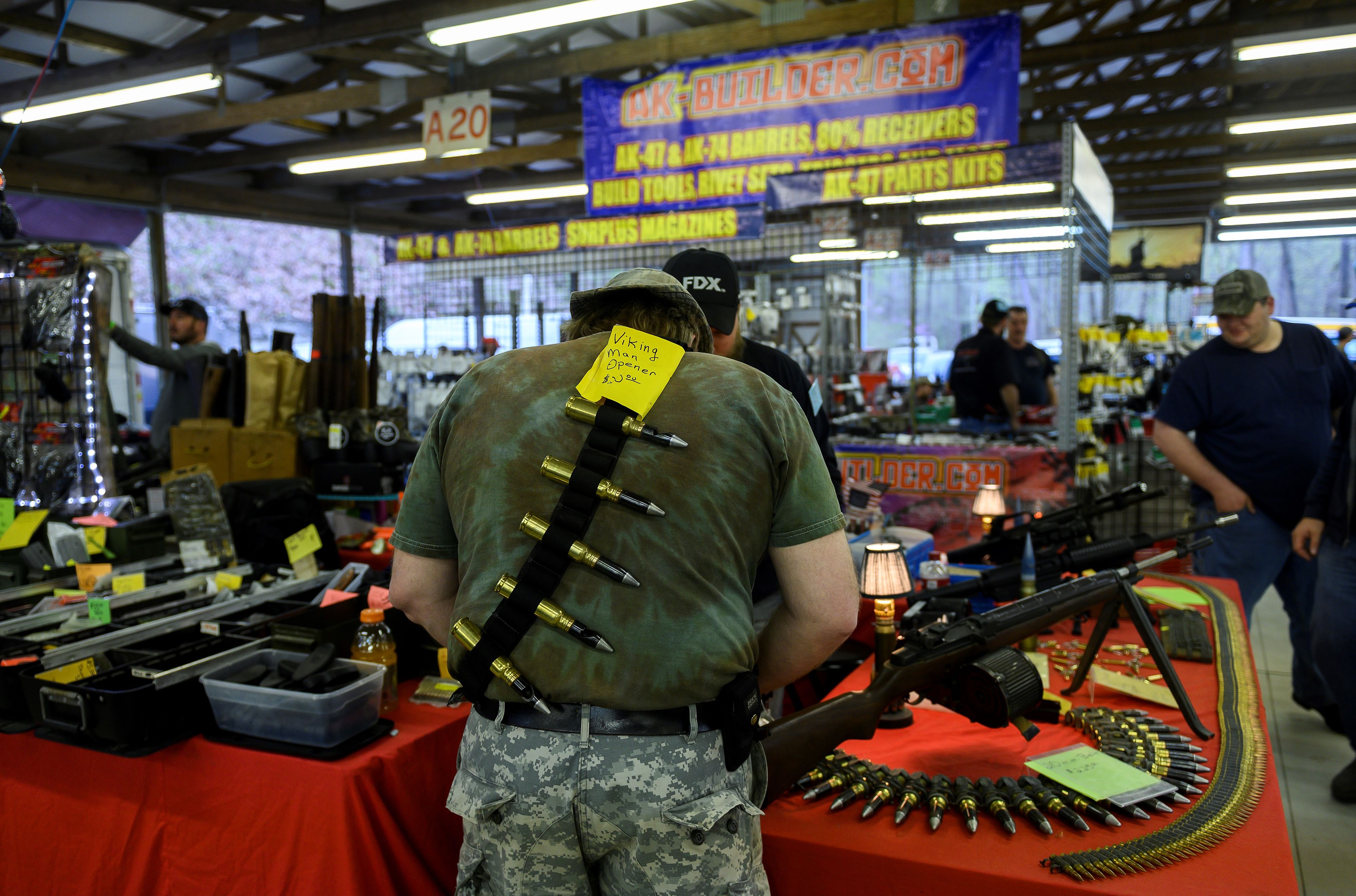 A man looks at gun parts at a vendors stand at the Knob Creek Machine Gun Shoot and Military Gun show. 1FM8CS.jpg