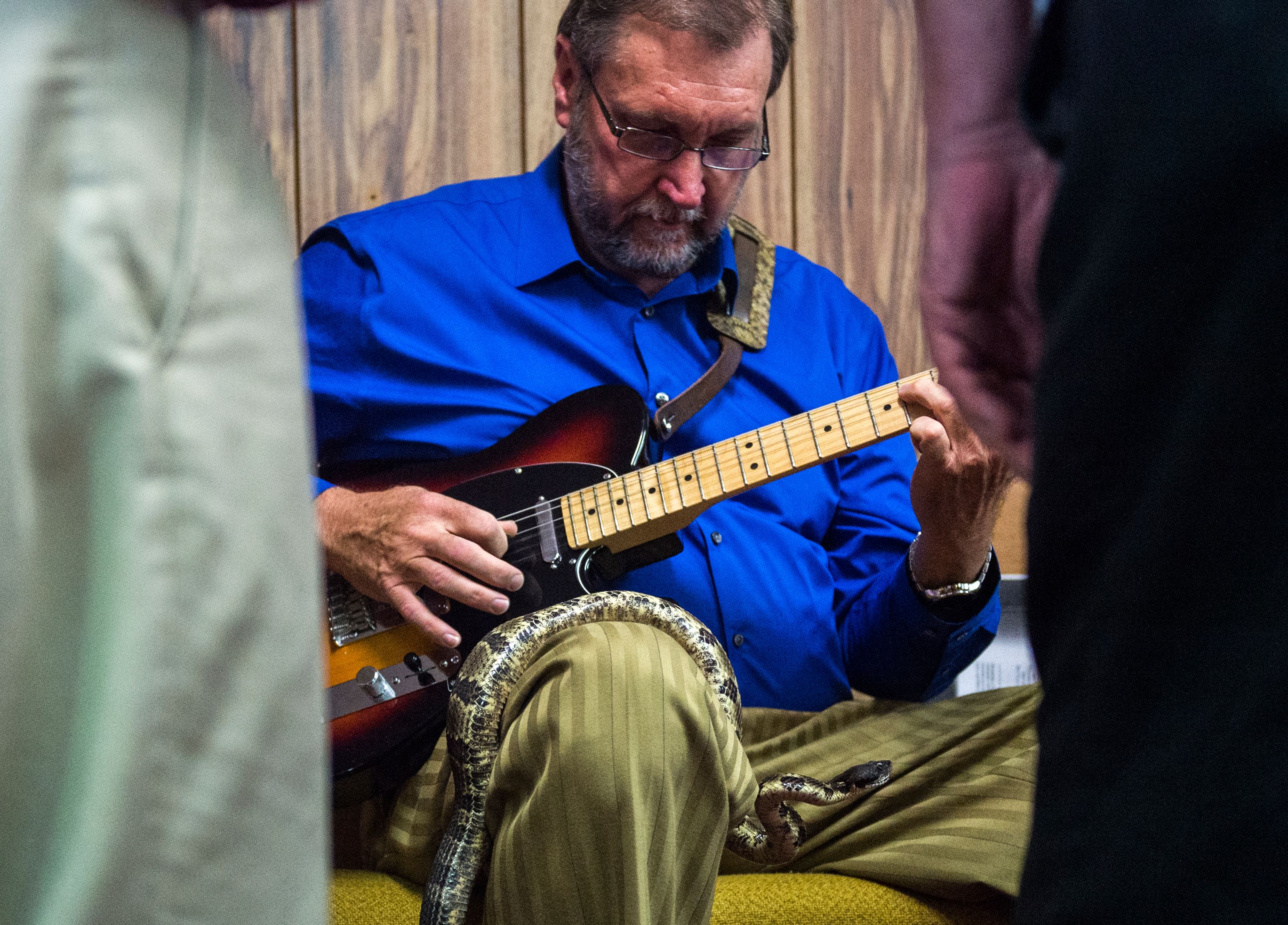 A worshipper plays the guitar as a timber rattlesnake rests on his lap during a Pentecostal serpent handlers service at the House of the Lord Jesus church. ACR_0660 copy.jpg