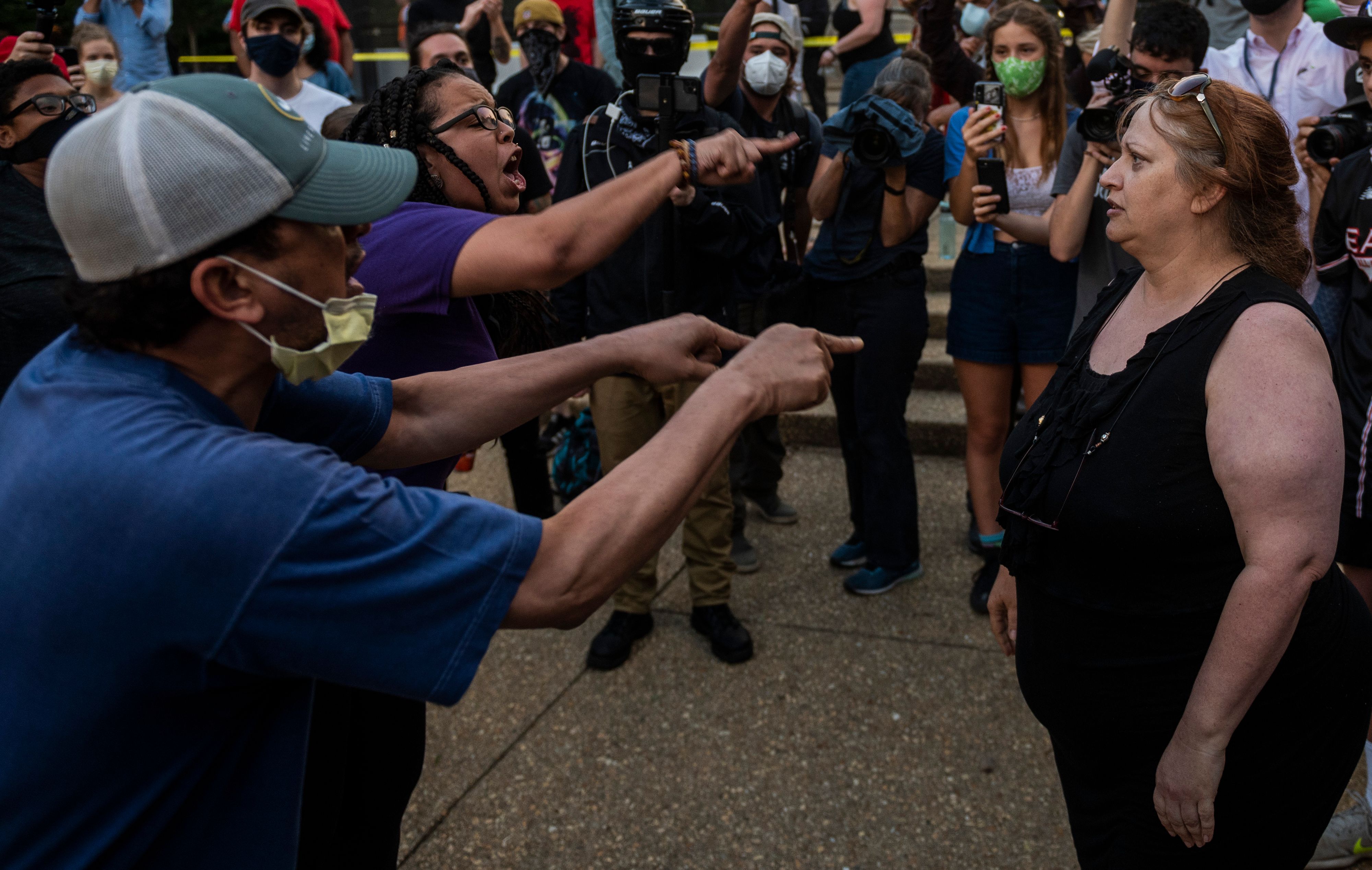 Anais (2L) an activist who wants the Emancipation Memorial removed, speaks with Suzzana Monk (R) at Lincoln Park in Washington, DC on June 25, 2020. 1U42CS.jpg