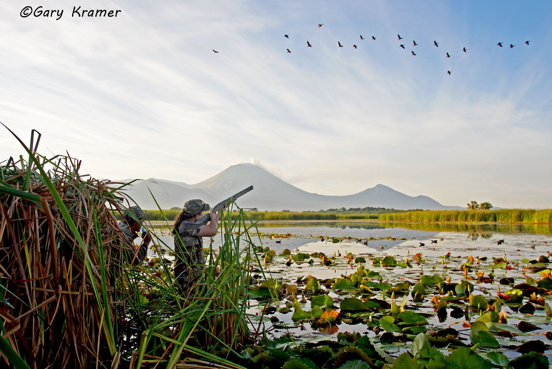 Hunter with guide shooting at Black-bellied Whistling Ducks over decoys Hunter with guide shooting at Black-bellied Whistling Ducks over decoys, Nicaragua - NHDmab#006d