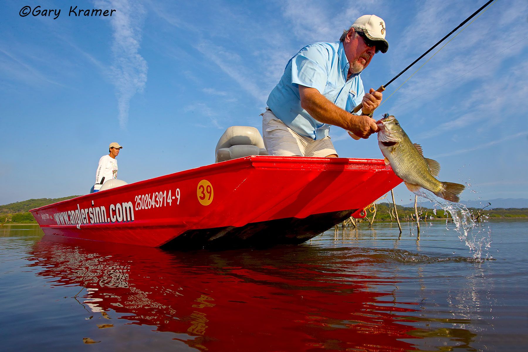 Flyfisherman landing a Largemouth Bass - NFBlf#191d