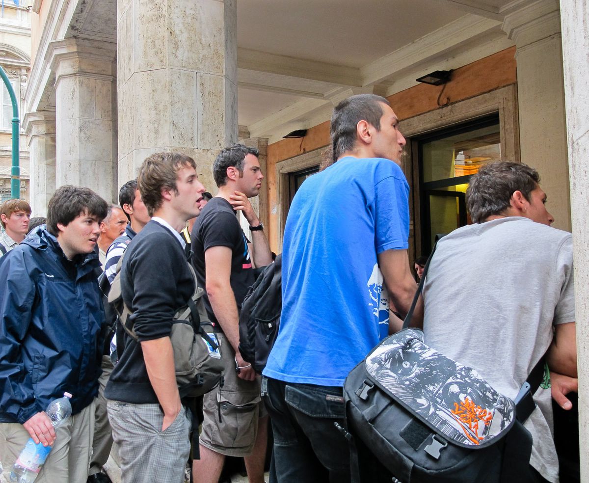 Italian young men watching football on restaurant television.