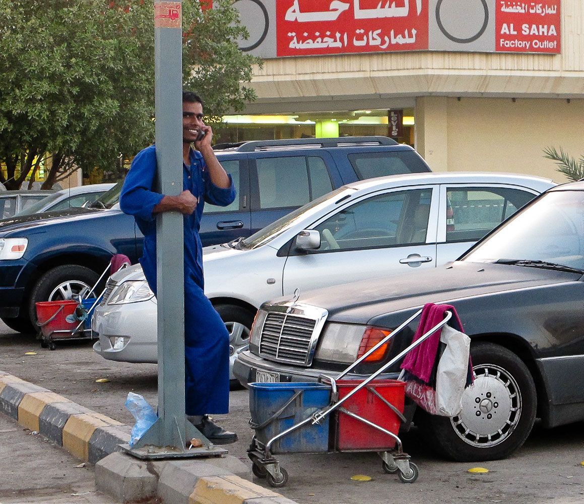 Arab man on phone with his with car wash business in shopping mall, Middle East