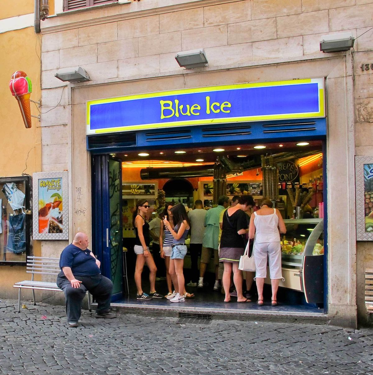 Fat Man watching girls as they buy gelato.