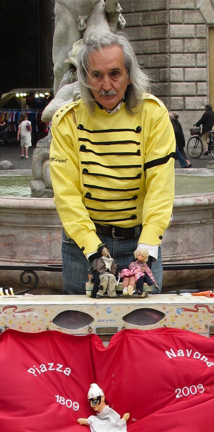 Old Roman puppeteer performing for the crowds.