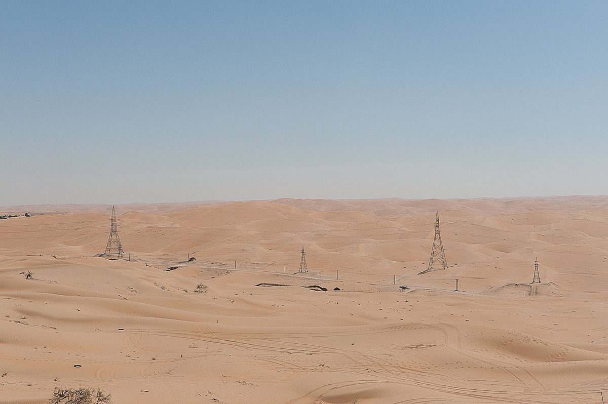 Oil fields for miles in desert country with sand smog.