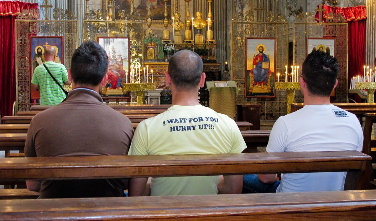 Three men in church praying.