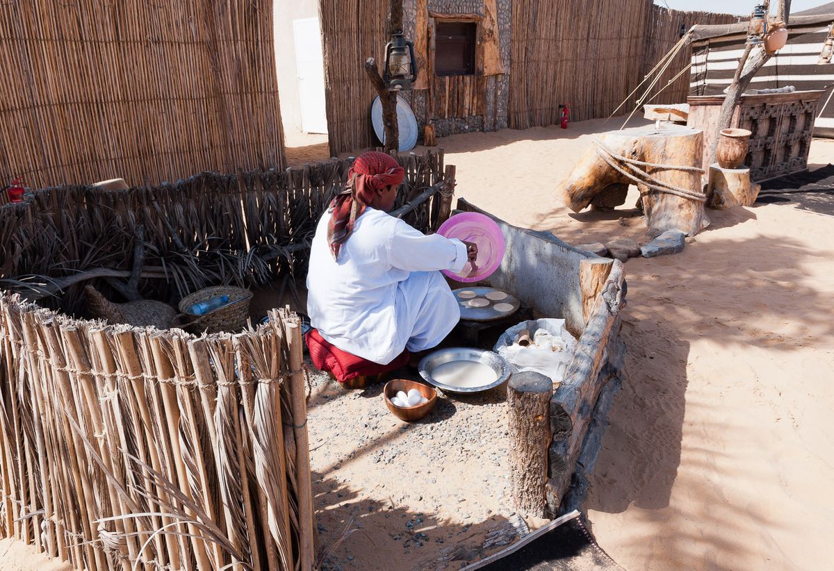 Cook at bedouin campsite making bread