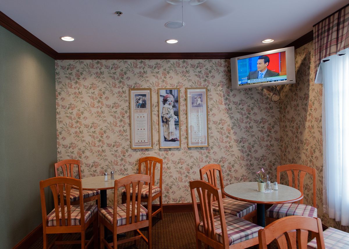 "Free Breakfast" room at chain motel with T.V. on.