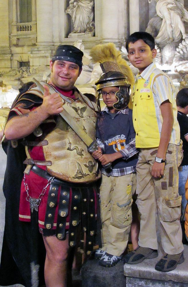 Tourist children posng with Roman Gladiator actor.