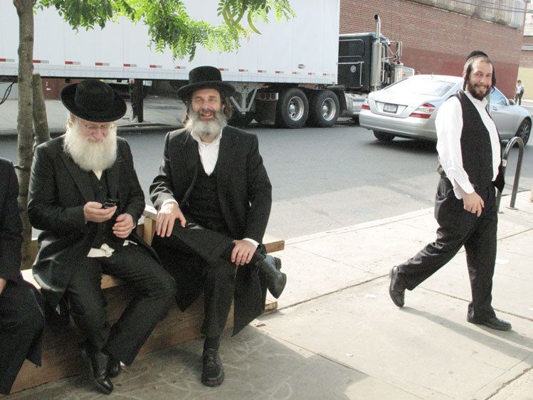 2 actors sitting and a real Hassidic walking (on the right) , Max, who owns a few buildings in the area.