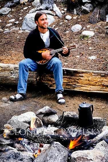 Backpacker playing a banjo at the campfire, high Sierra backcountry, Kings Canyon National Park, California ©Londie Garcia Padelsky ES35-3133_LondieGPadelsky