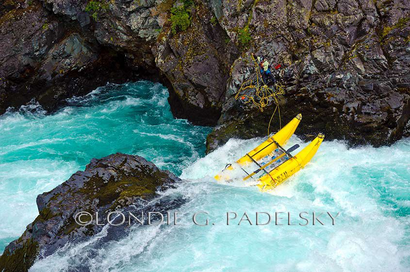 While 'ghosting the boats' down Throne Room-Class V Rapid, the boatman has to dislodge the Cataraft that got stuck in a eddy. Rio Futalefu, Patagonia, Chile, South America ©Londie G. Padelsky 11SAC_LGP2079_LondieGPadelsky