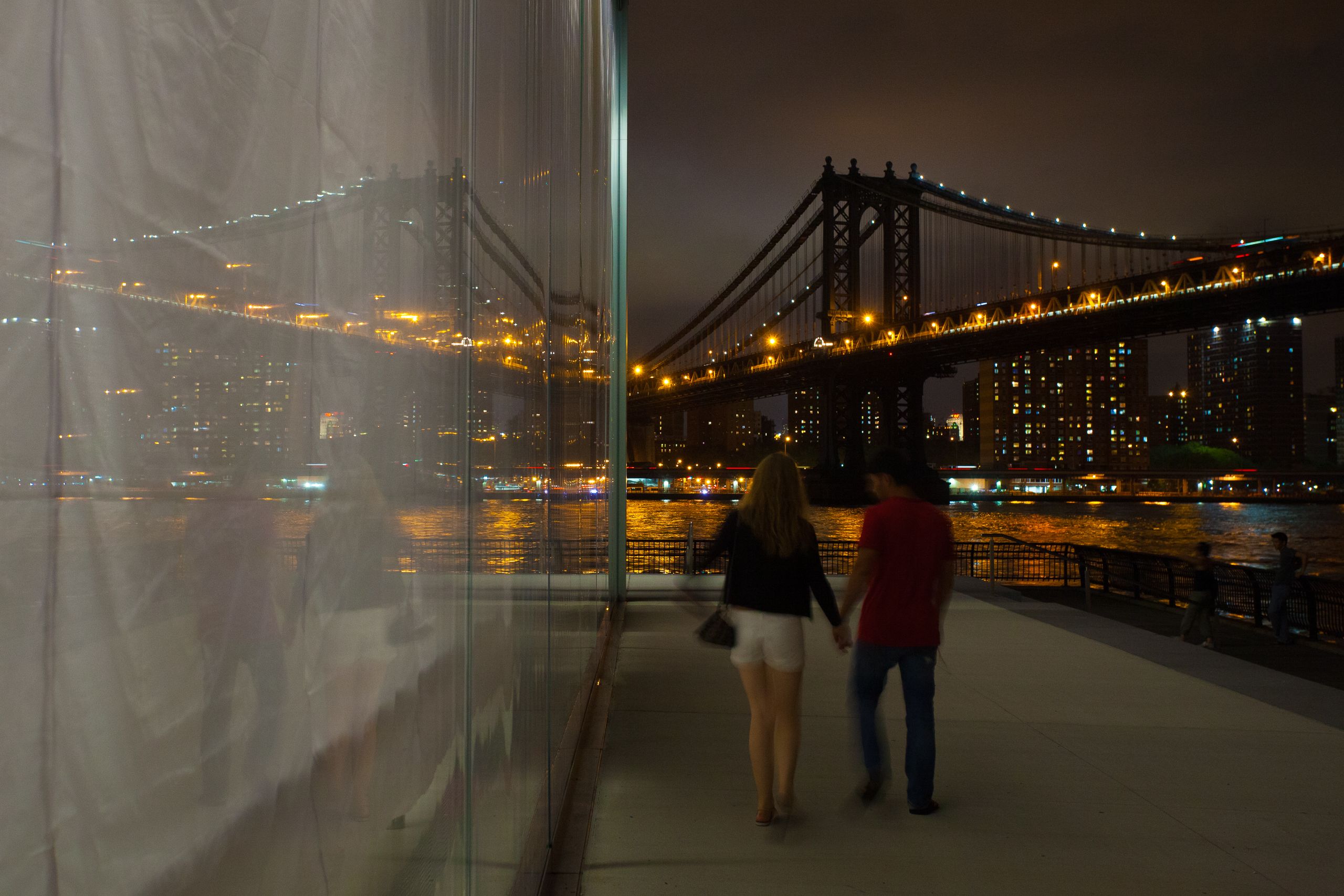 Brooklyn, New York A Couple Walks By The Brooklyn Bridge Park Carousel Enclosure