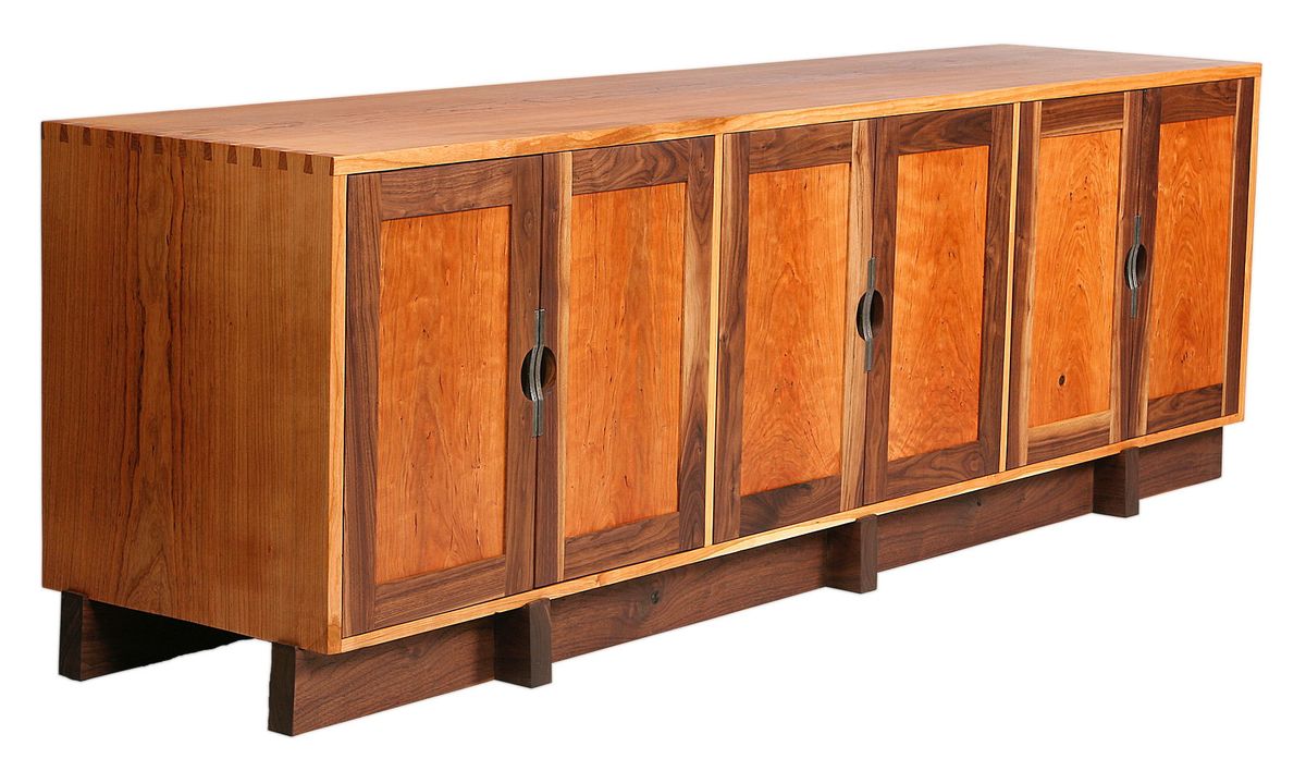 Shown in cherry and walnut.  Hand-cut dovetail joints, recessed pocket doors of book-matched quilted cherry, and custom pulls of acid-etched wrought iron.  Available in a wide array of woods and custom sizes. Tamarind credenza
