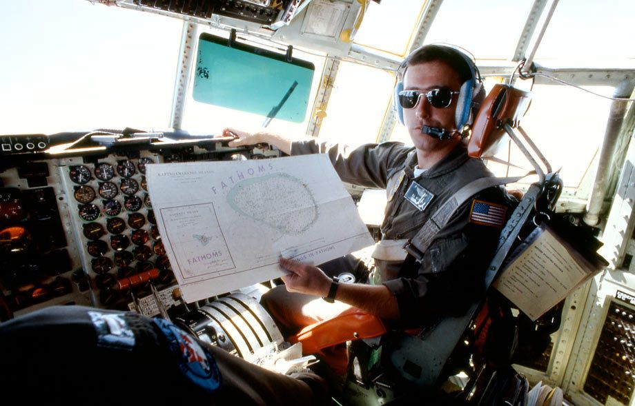 USAF C-130 Hercules pilot showing map of south pacific air route and airdrop points, South Pacific
