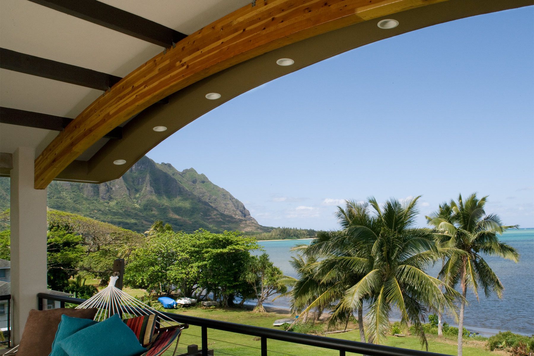 This project was designed to replace an existing 1200 s.f. home that had been abandoned and was near collapse. The previously underutilized site overlooks Kaneohe Bay and also has Mauka views of the Ko'olau Mountain Range. The modern architectural design utilizes local construction material such as moss rock cladding, local fauna and flora, as well as deep roof overhangs to provide a new take on Hawaiiana vernacular. The curvilinear roof was specifically sighted to mirror the adjacent Koolau foothill topography and to maintain adjacent property owners’ ocean view planes. Vaulted ceilings with vented clerestories and an energy efficient roof were employed to minimize life cycle costs. LOT AREA: 8425 s.f. / LIVING AREA: 3095 s.f. / BUILT AREA: 3921 s.f. Waikane Hale