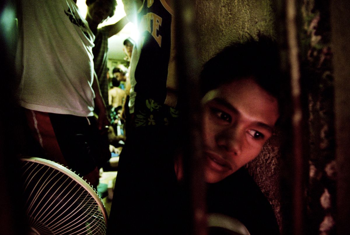 Dennis, 15 yrs old. His cell is only 1 metre by 5 metres in size, sharing with 11 adult men and one other child. There is not enough room for them all to sit on the ground, so they take it in turn to sit and sleep, while others stand.© Hazel Thompson Kids Behind Bars
