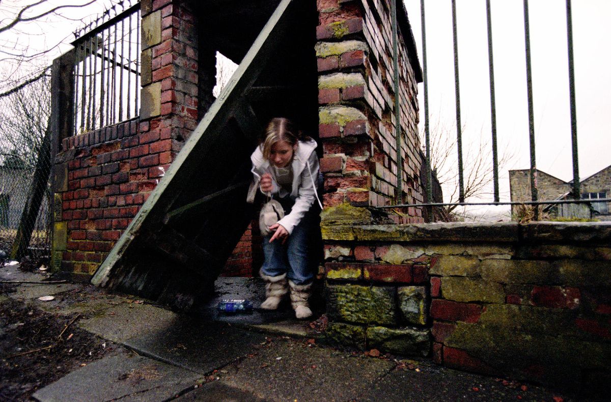 Danielle, aged 14 sneaking out of an abandoned factory in Burnley. She stays in dangerous places and buildings, and hangs out with street gangs and drug dealers.© Hazel Thompson Home and Away