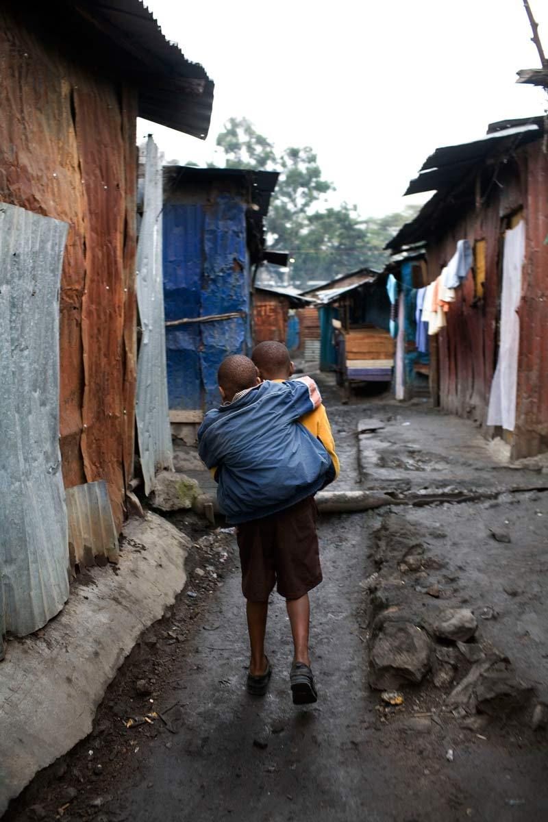 Mutava carrying Braise back from school through the Marigoini slums to their homes.© Hazel Thompson Carried on friendship