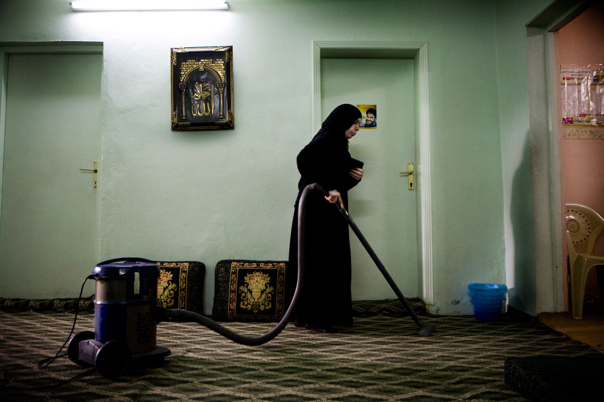 Bibi, aged 70 a widow and mother of 6 children, doing some housework in her home, Bahrain.© Hazel Thompson Measure of a Woman