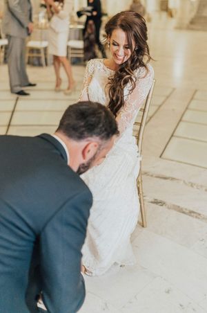 Groom and bride during garter removal Reception