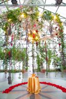 Flower-Decked Ceremony Area Under Hanging, Greenery with Lighted Chandelier Details