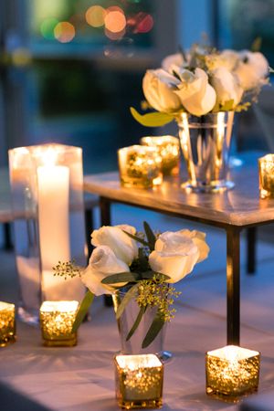 Lighted Candles With White Roses Rehearsal Dinner