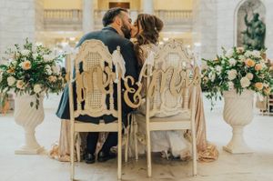 Bride and groom kiss at sweetheart table Reception