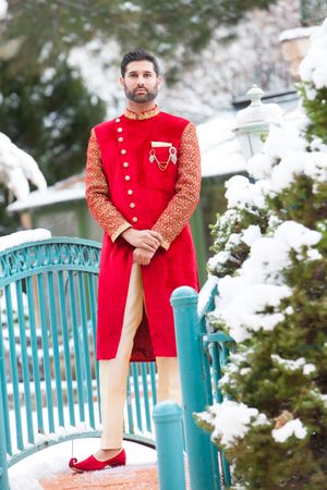 Scarlet-Costumed, Indian Groom Posing on Pale Blue Bridge - Wedding Day Pre-Ceremony