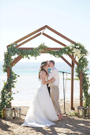 Hoopes Events | Aspyn and Steven | Bear Lake Utah | Couple Kissing in Front of Flower-Accented Wooden Arch Aspyn_Steven_Bear_Lake_Utah_Couple_Kissing_Wooden_Arch.jpg