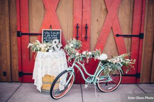 Hoopes Events | Charming Barn Wedding | Quiet Meadow Farms | Mapleton Utah | Vignette Table and Bicycle in Front of Red-Accented Barn Door Charming_Barn_Wedding_Quiet_Meadow_Farms_Mapleton_Utah_Vignette_Table_Bicycle_Red-Accented_Barn.jpg