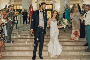 Bride and groom walk down stairs during send off Send Off