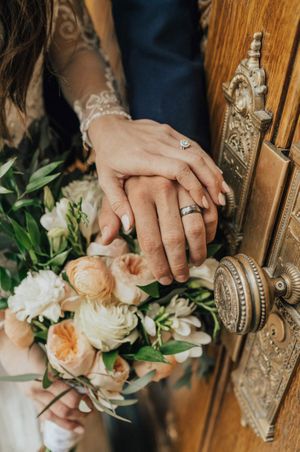 Bride and groom place hands with wedding rings After Ceremony