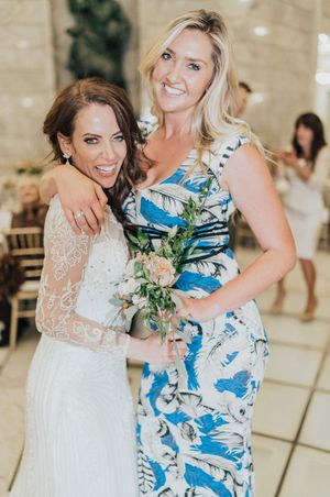 Bride hugs bouquet toss winner Reception