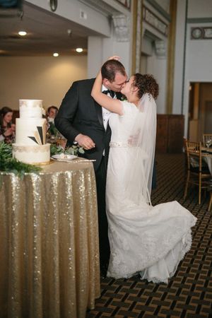 Hoopes Events | Chloe and Austin | Ben Lomond Suites | Ogden Utah | The Great Gatsby Wedding | Bride and Groom Kiss After Cutting Wedding Cake Chloe_Austin_Ben_Lomond_Suites_Ogden_Utah_Great_Gatsby_Kiss_After_Cake.jpg
