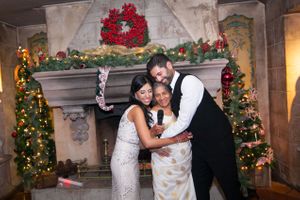 Couple with Grandmother in Front of Festive, Holiday-Decorated Fireplace Reception
