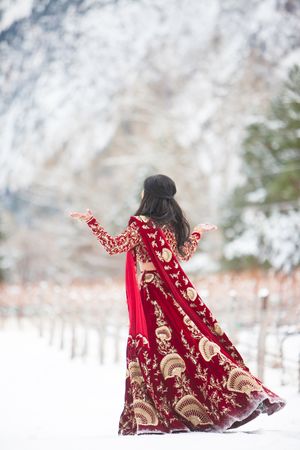 Bride in Stunning Burgundy and Gold Dress with Snow-Covered Background Pre-Ceremony