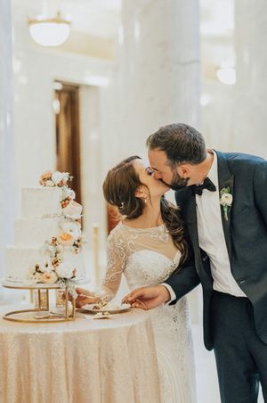 Bride and groom kiss after cutting the cake Reception