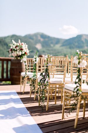 Flower and Greenery Accented Chairs Ceremony
