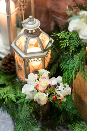 Lighted Lantern With Evergreens and White Roses Rehearsal Dinner Details
