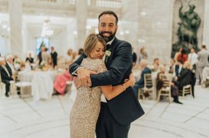Groom hugs mother during reception Reception