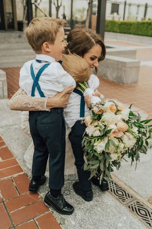 Bride hugs ring bearers outside temple After Ceremony