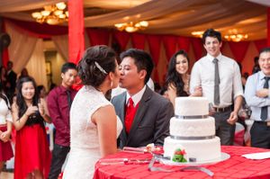Bride and Groom Kiss During Cake Cutting Reception