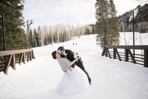 Kissing on the Snow-Covered Bridge Bride and Groom