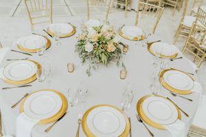 Tablescape with flower centerpiece, gold votives, and gold chargers Reception Details